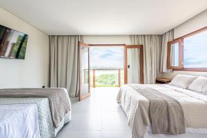 a hotel room with two beds and a large window at River & Ocean View House with Pool in Igarassu