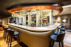 a bar in a restaurant with stools at NH Collection Copenhagen in Copenhagen +87 photos