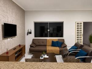 a living room with a couch and a tv at Casa Completa próxima ao Centro in Passos +26 photos