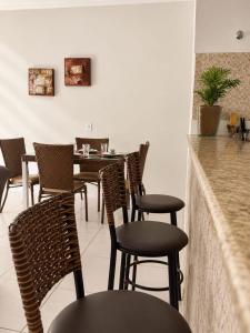 a restaurant with chairs and a table and a counter at Casa Completa próxima ao Centro in Passos
