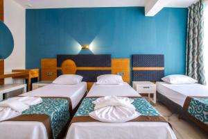 a room with three beds and a blue wall at Dublin Hotel in Alanya +69 photos