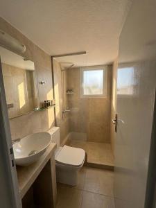 łazienka z toaletą, umywalką i lustrem w obiekcie Kirki Rooms by the sea w mieście Parikia +50 zdjęć
