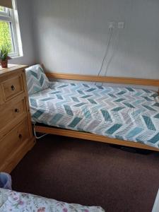 a small bedroom with a bed and a dresser at Grand Chalet 64 Disabled Friendly in Skegness
