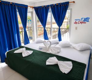 a bedroom with a bed with blue curtains and bows at Hotel Los Delfines Melgar in Melgar +37 photos