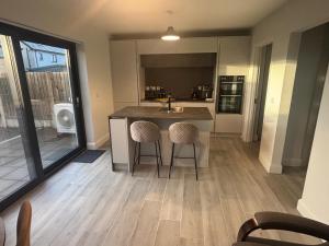 a kitchen with a sink and a counter with two chairs at No2 WestPoint Donegal Town in Donegal