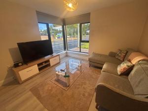 a living room with a couch and a flat screen tv at No2 WestPoint Donegal Town in Donegal