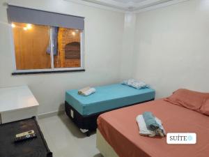 a room with two beds and a window at CASA MARIANNA em Paracuru - Piscina, 3 quartos, ar condicionado e perto de tudo! in Paracuru +23 photos