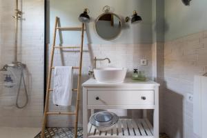 a bathroom with a white sink and a mirror at Ático FUENTE HERVERA in Vega de San Mateo +12 photos