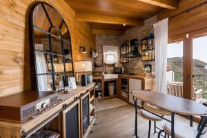 a kitchen with a table and a dining room at Ático FUENTE HERVERA in Vega de San Mateo