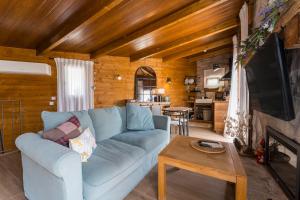 a living room with a blue couch and a table at Ático FUENTE HERVERA in Vega de San Mateo