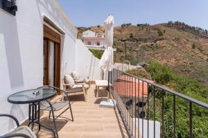 a balcony of a house with a table and chairs at Ático FUENTE HERVERA in Vega de San Mateo