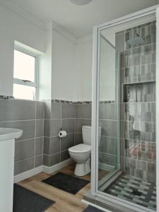 a bathroom with a toilet and a glass shower at Guests at 32 Nautilus Bay in Dana Bay