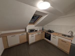 a kitchen with white cabinets and a sink and a window at Mainrooms Kelsterbach in Kelsterbach