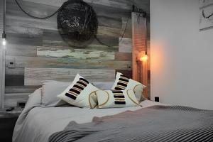 a bedroom with a bed with pillows and a wooden wall at 4 Rest in a warm and comfortable loft in Coihaique