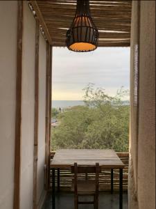 a table and chairs in a room with a window at Los Asentamientos in Máncora