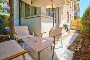 two chairs and a table and an umbrella on a patio at Charming city in Lausanne
