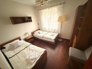 a small room with two beds and a window at Lawendowa Ostoja - dom na wyłączność in Uście