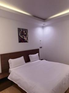 a bedroom with a large bed with white sheets at Junto Al Mar - Chambre standard in San-Pédro