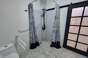 a bathroom with a toilet and a shower with curtains at 6 Universal Access Comfort WiFi central heating in Coihaique +8 photos