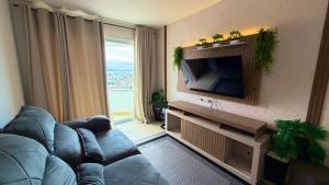 a living room with a blue couch and a television at Condomínio próximo a ponte Hercílio Luz in Florianópolis