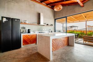 a kitchen with an island in the middle of a room at La Morada Punta Sal - Casa de playa frente al mar in Canoas de Punta Sal