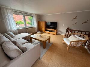 a living room with a couch and a tv at Fischerhaus Lemkenhafen in Lemkenhafen auf Fehmarn