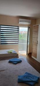 two beds in a room with a large window at Vila Angeli in Techirghiol