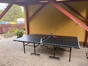 a black ping pong table in a patio at Lawendowa Ostoja - dom na wyłączność in Uście