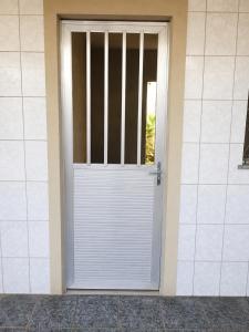 a white door with a gate in a building at Villa Santa Terezinha in Mesquita