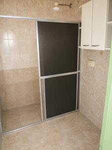 a shower with a glass door in a bathroom at Villa Santa Terezinha in Mesquita