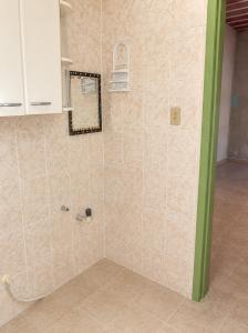 a shower in a room with a tiled wall at Villa Santa Terezinha in Mesquita