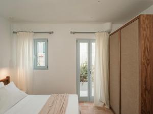 a bedroom with a white bed and a window at Villa Sol Mare Naousa, Paros in Naousa +34 photos