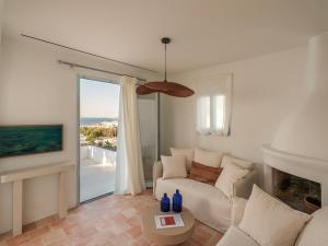 a living room with a couch and a fireplace at Villa Sol Mare Naousa, Paros in Naousa