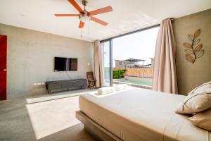 a bedroom with a large bed and a flat screen tv at La Morada Punta Sal - Casa de playa frente al mar in Canoas de Punta Sal