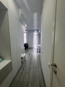 an empty room with a hallway with a wooden floor at Apartament in Batumi +3 photos