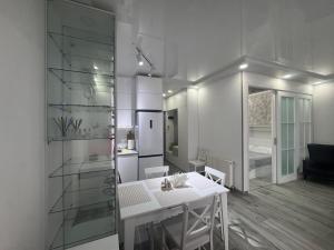 a living room with a white table and a kitchen at Apartament in Batumi