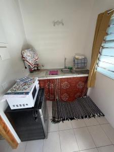 a small kitchen with a sink and a microwave at Orivai Lodge in Fare