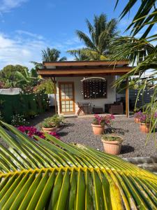 a garden with a small house with plants and flowers at Orivai Lodge in Fare