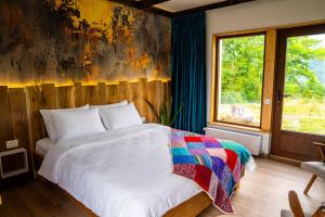 a bedroom with a bed with a colorful blanket at K-Home in Stănija