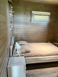 a bedroom with a bed in a wooden wall at Houseboat Przystań Spokoju in Ślesin