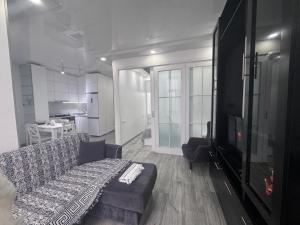 a living room with a couch and a flat screen tv at Apartament in Batumi