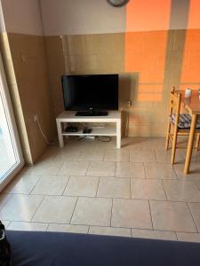 a living room with a television on a table at Casa Marelia - studio A2 in Primošten