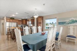 a dining room with a blue table and white chairs at Sea Breeze 101 Beach Bliss in St. Pete Beach