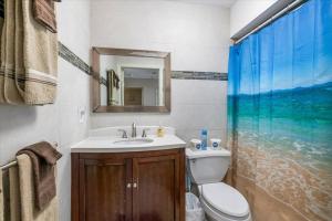 a bathroom with a sink and a toilet and a mirror at Sea Breeze 101 Beach Bliss in St. Pete Beach +25 photos