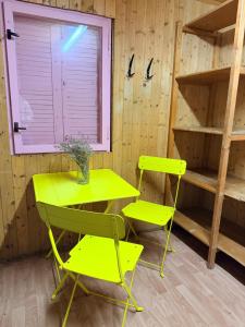 a yellow table and two chairs in a room at Basecamp Brno in Brno