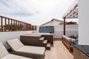 a balcony with a desk and chairs at Rooftop Penthouse Jacuzzi, 2 Pools Playa Popy 500m in Las Terrenas