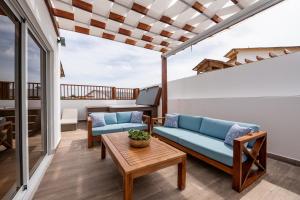 a balcony with blue couches and a table at Rooftop Penthouse Jacuzzi, 2 Pools Playa Popy 500m in Las Terrenas