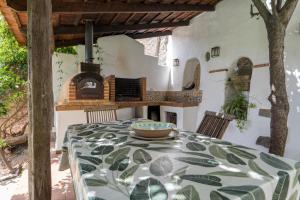 a dining room with a table and a wood fired oven at Casa Fuente Hervera in Vega de San Mateo