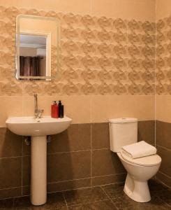 a bathroom with a toilet and a sink and a mirror at Roadhouse New Cairo Residence in Cairo +13 photos
