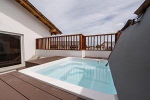 a hot tub on a deck with a balcony at Rooftop Penthouse Jacuzzi, 2 Pools Playa Popy 500m in Las Terrenas